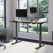 Electric Standing Desk 60x30 Walnut in raised position at home